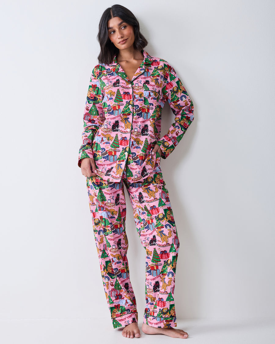 Full front view of a person wearing the candy pink long pajama set with a collared button-front top and matching pants in a Christmas cat print.