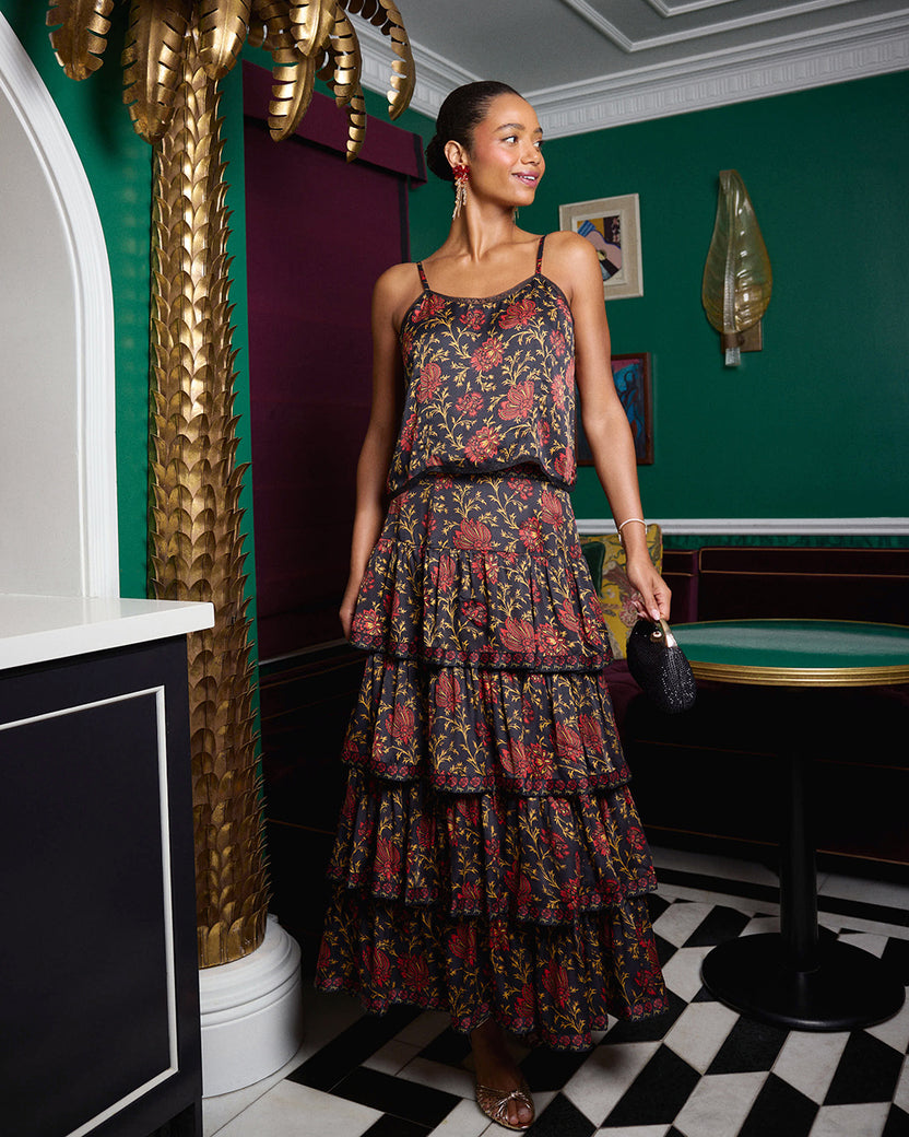 Person wearing the Noelle Set, a floral-print camisole top and tiered maxi skirt, indoors.