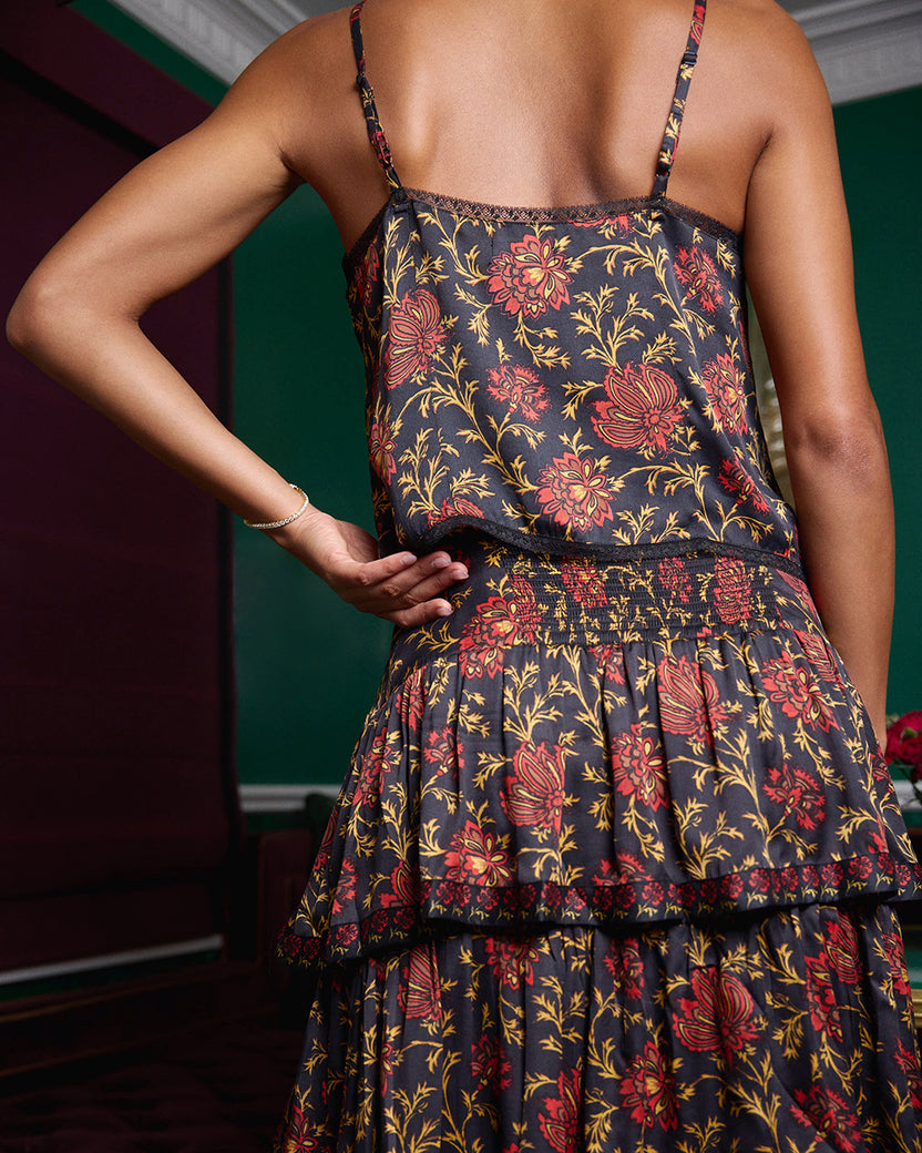 Back view of the Noelle Set showing camisole straps, a gathered waistband, and a tiered floral-print skirt.