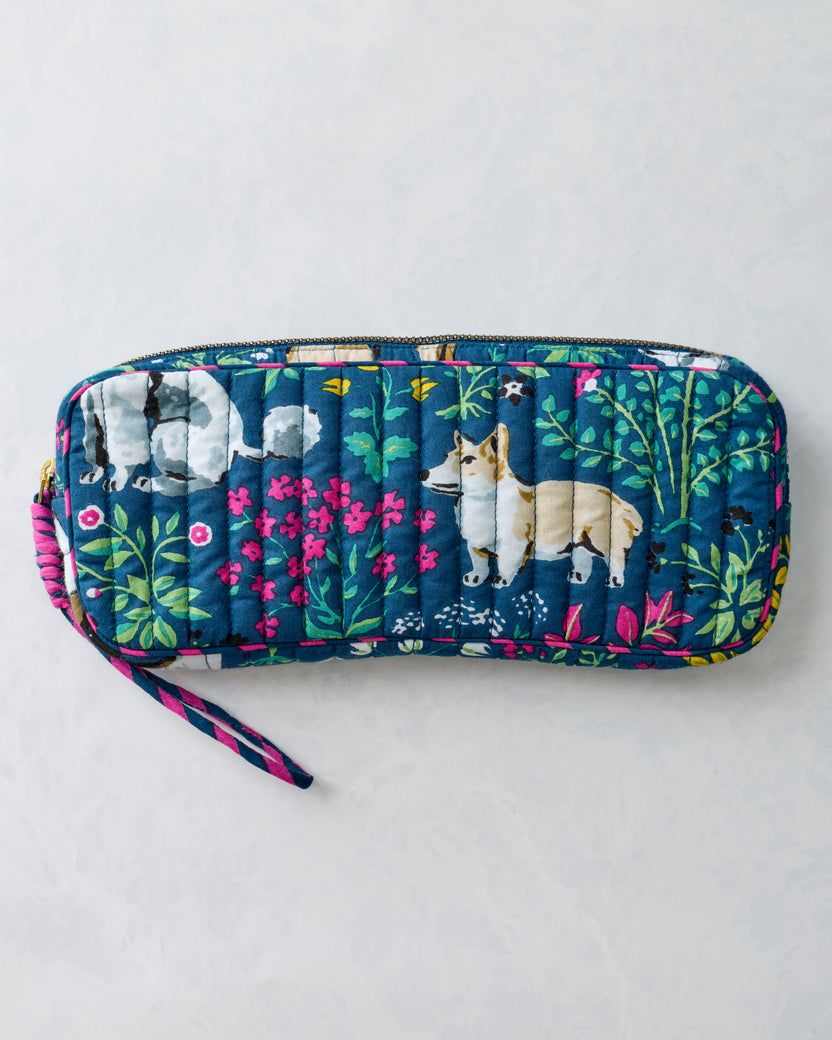 Front view of a quilted indigo zippered sunglasses case with dog and floral print and a wrist strap.