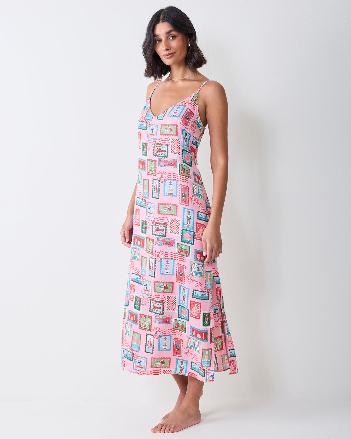 Full-length front view of a person wearing the pink Nautical Stamps Eco Satin Chic To Sleep Nightie with thin straps and a midi-length hem.