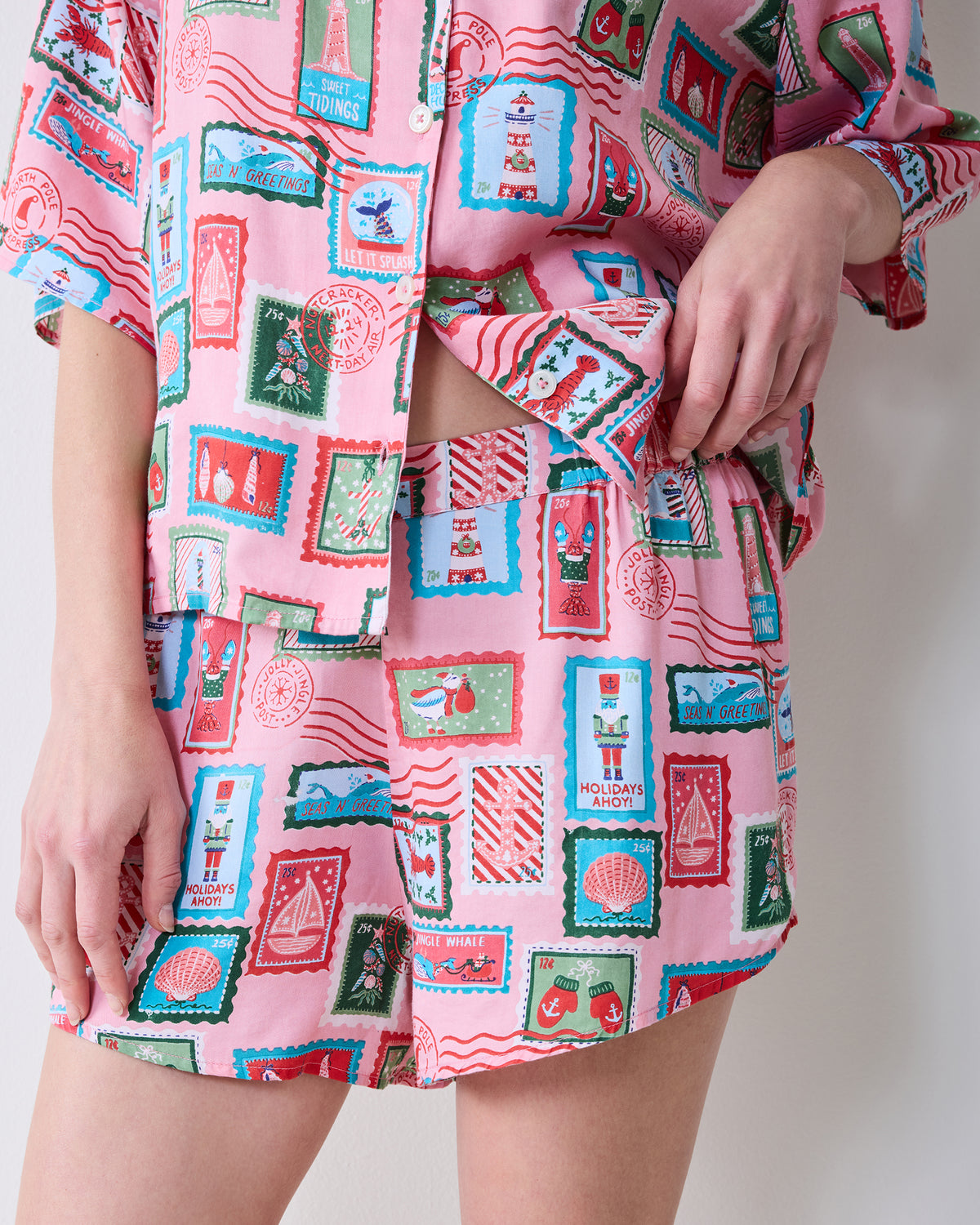 Close view of the pink Nautical Stamps pajama shirt and matching shorts, showing the elastic waistband and postage-stamp print.