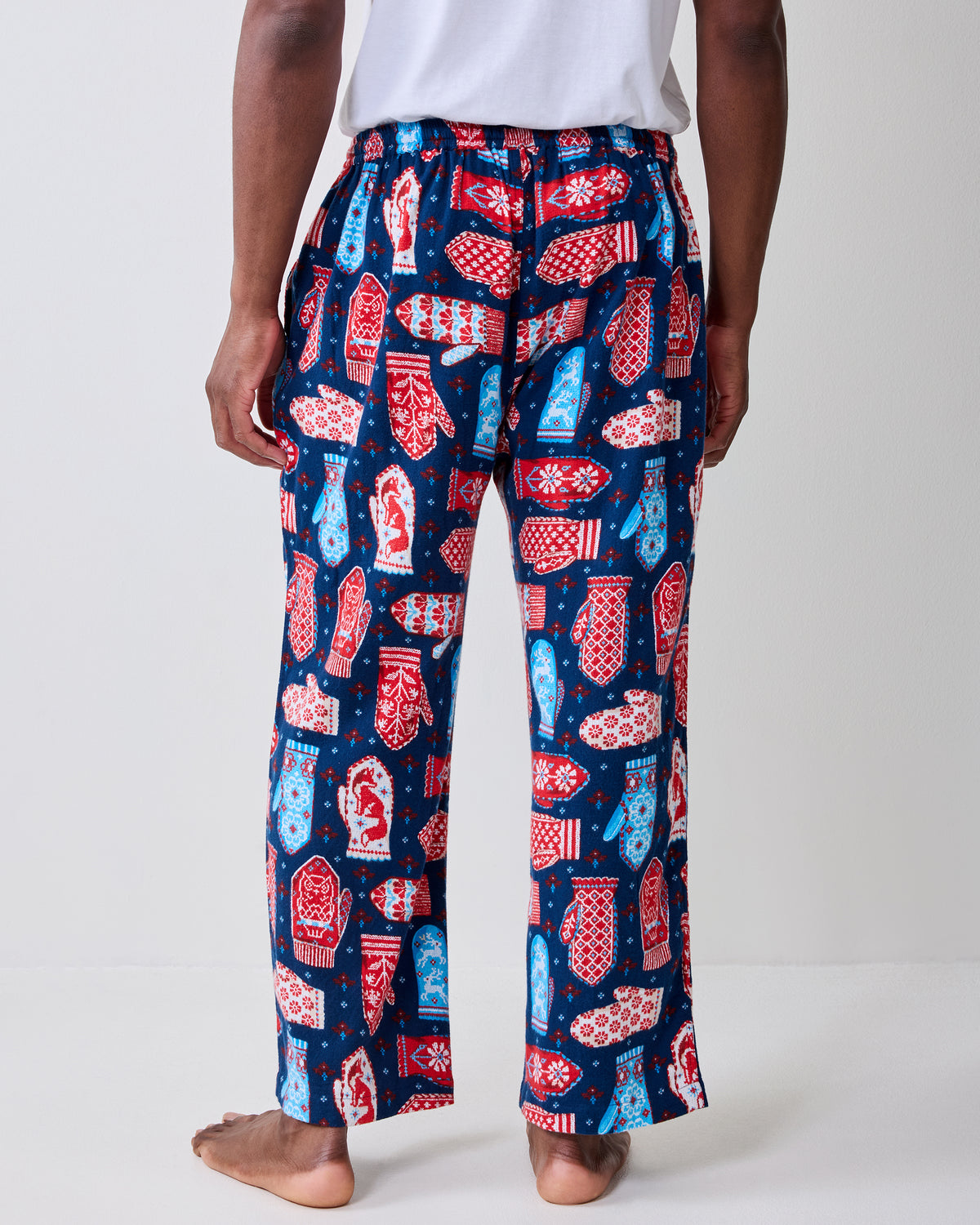 Back view of blue flannel men's pajama pants with a red, white, and light blue mitten print.