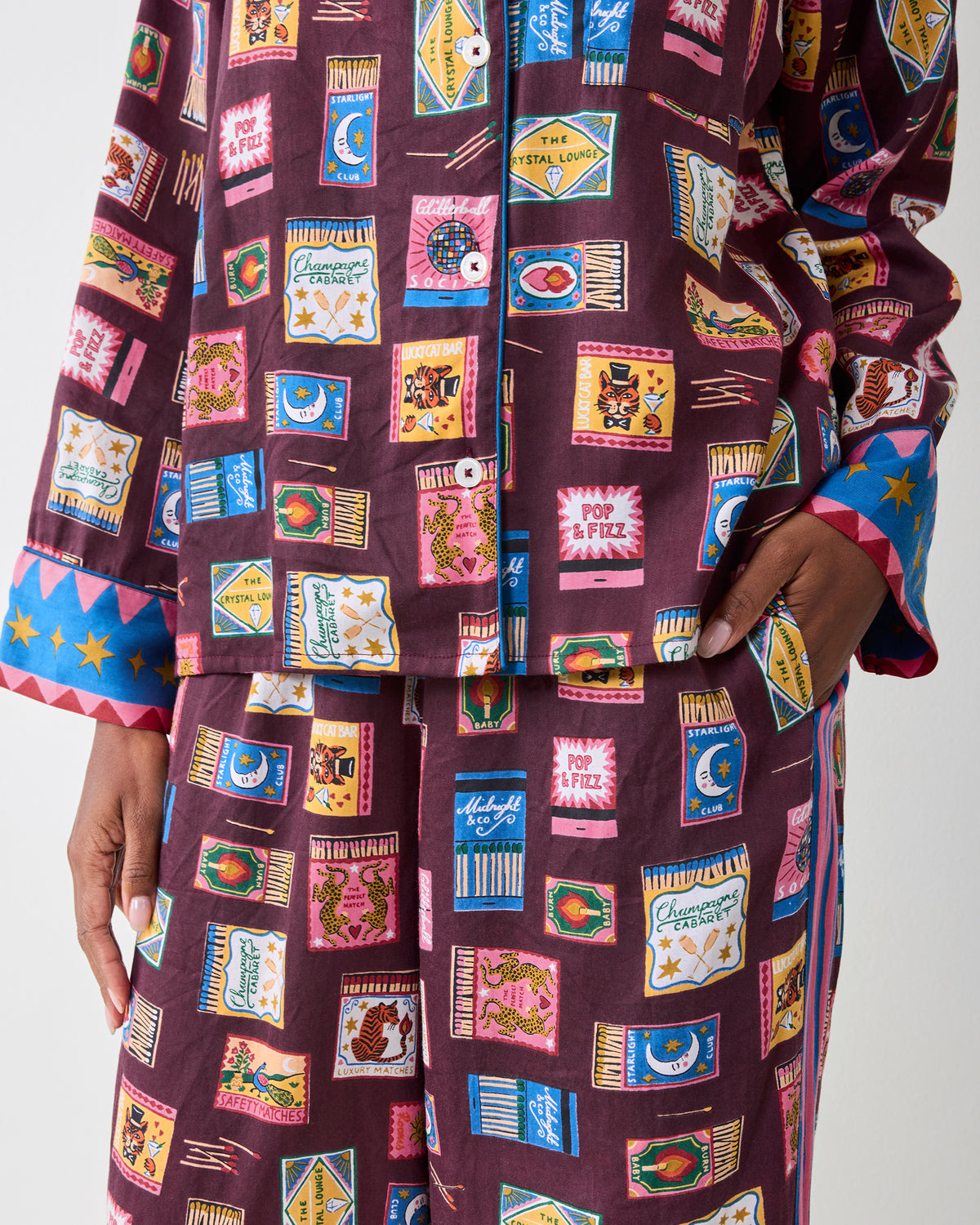 Close-up of the Painted Matchbook Cabernet pajama set, showing the button-front top, pocket, cuffs, and matchbook print.
