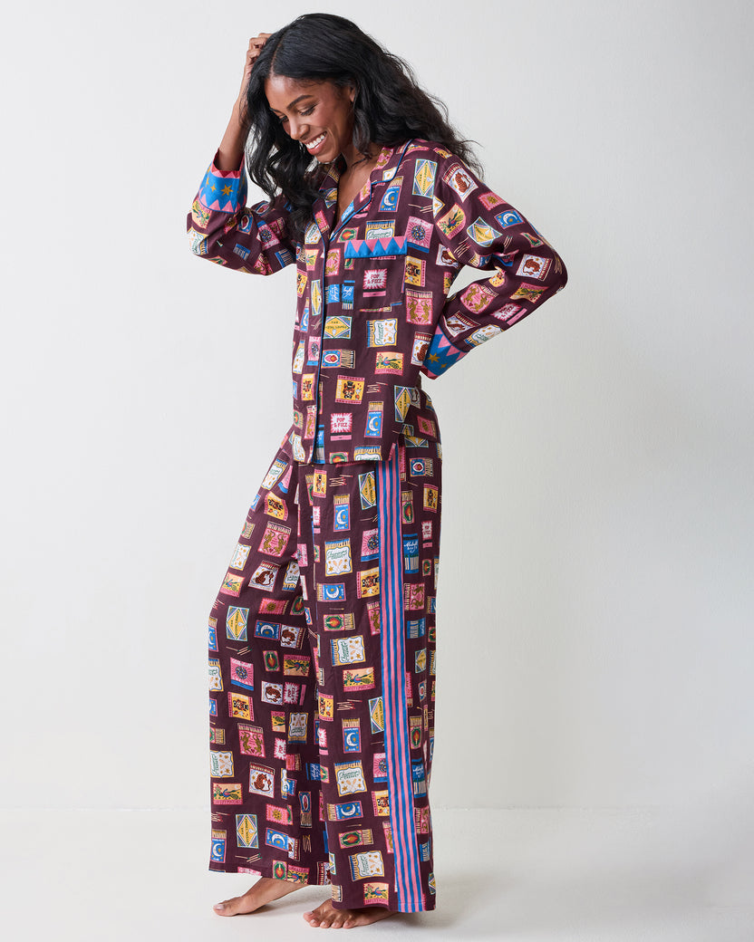 Full-length side view of the Cabernet Painted Matchbook pajama set with a button-front top, wide-leg pants, contrasting cuffs, and side stripes.