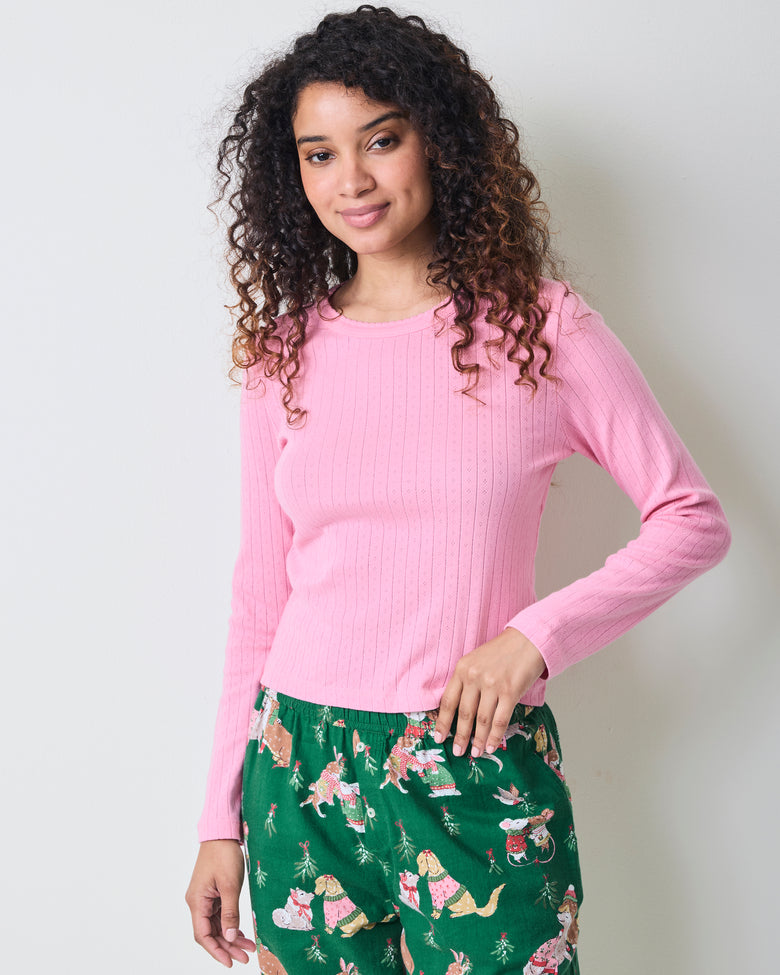 Front view of the pink taffy long-sleeve pointelle top with scalloped neckline and green patterned pajama pants.