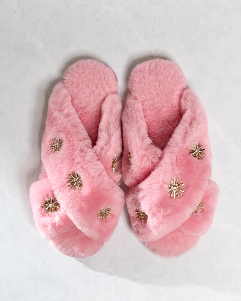 Pair of pink sheepskin slippers with rhinestone embellishments, shown from above.