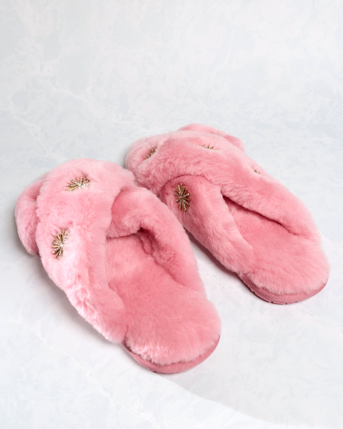 Pair of pink slippers shown from the side and inside, with rhinestone embellishments on the straps.