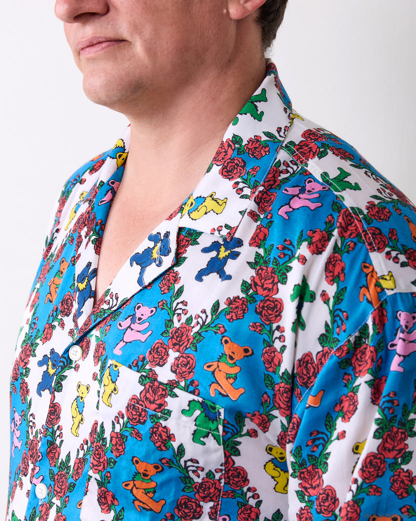 Close-up of the pajama top showing its notched collar, white buttons, and colorful bear-and-rose print.