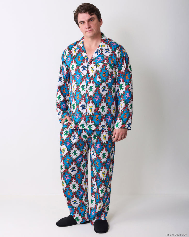Model wearing a long button-front pajama set with a colorful bear-and-rose print, shown from the front.