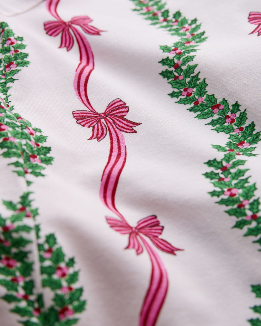 Close-up of the Ribbons & Bows Vanilla Cream pajama print, showing alternating green garlands and pink ribbon bows.