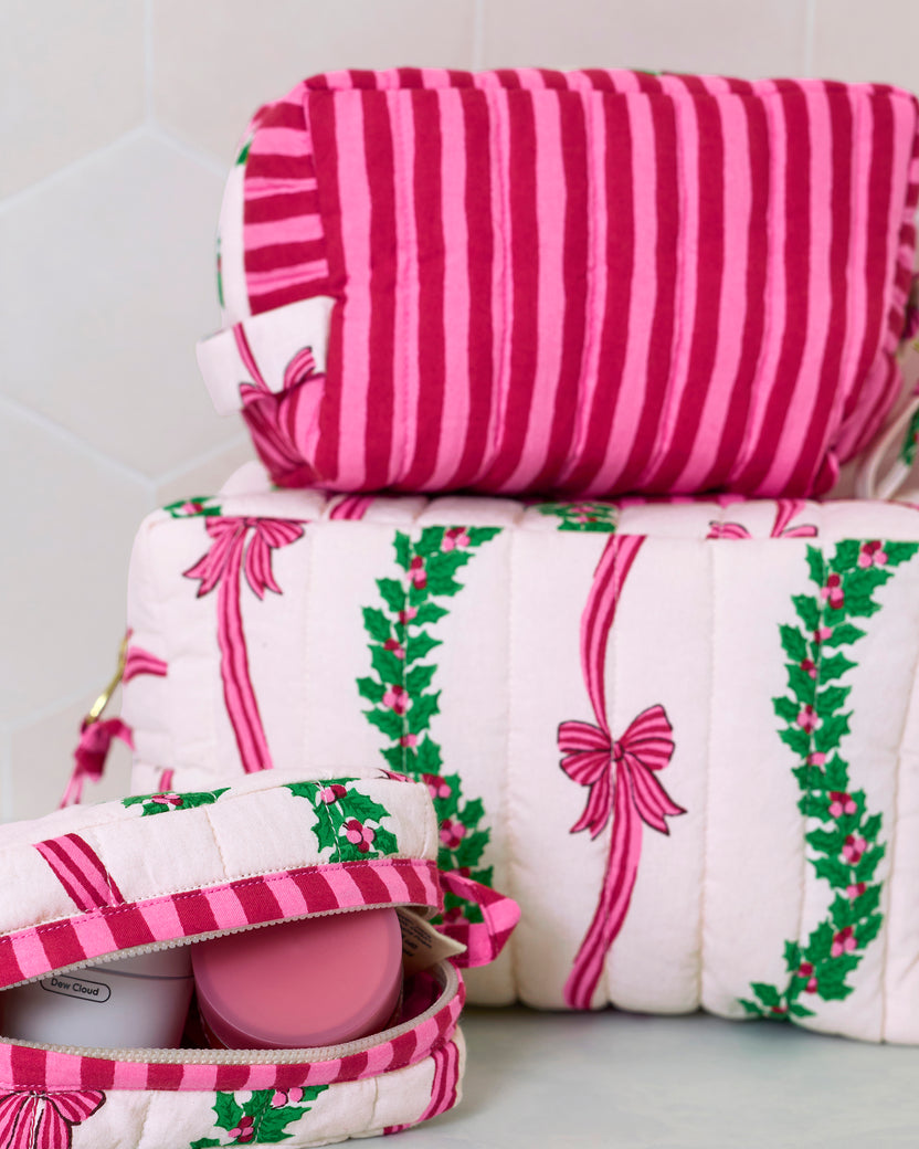 Close-up of the stacked quilted pouches, showing the pink striped pouch and the open pouch with containers inside.