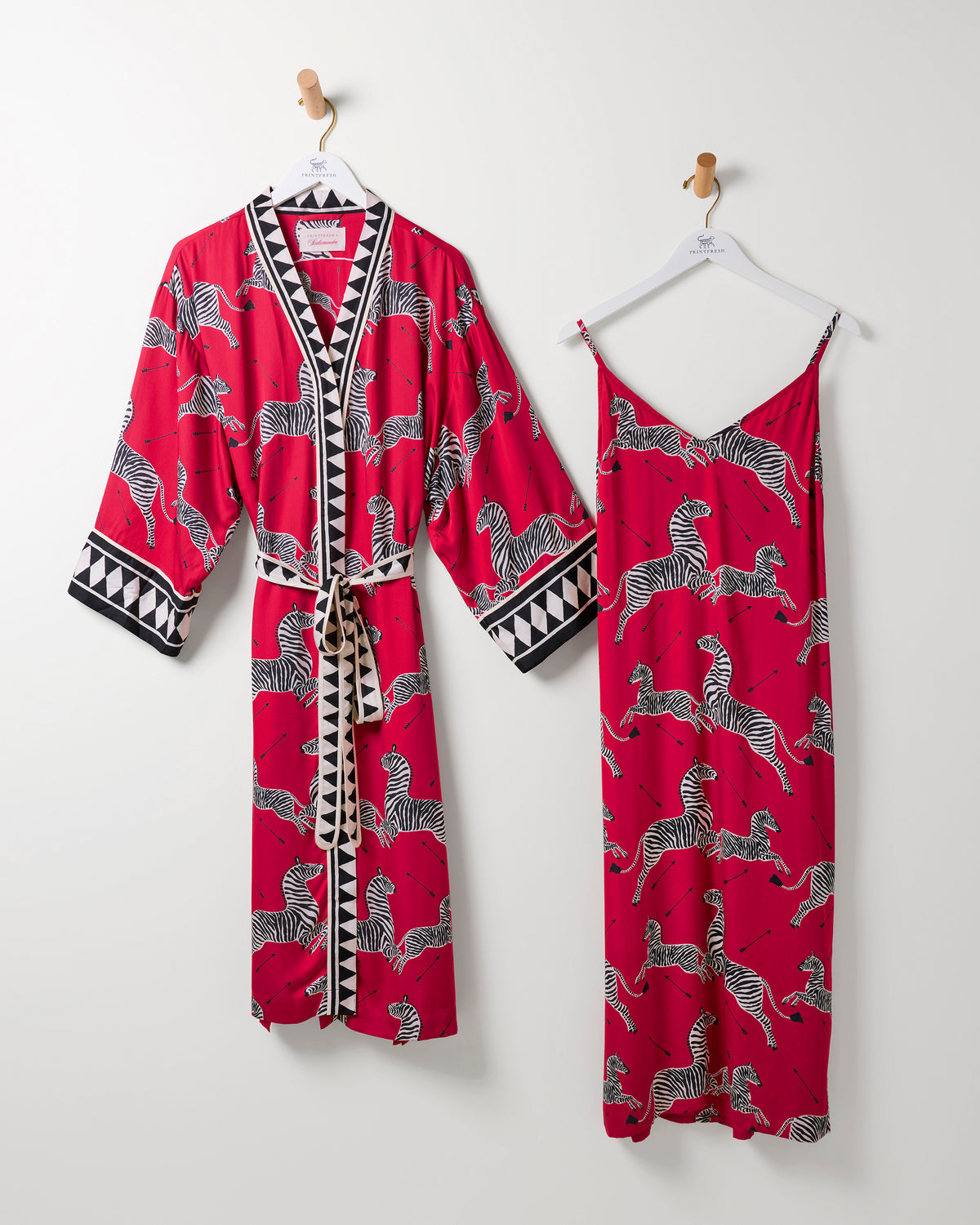 Masai red zebra-print robe and matching camisole nightie hanging side by side.