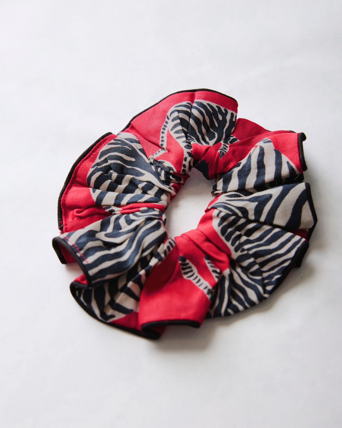 Red scrunchie with black-and-white zebra stripes arranged in a circle.