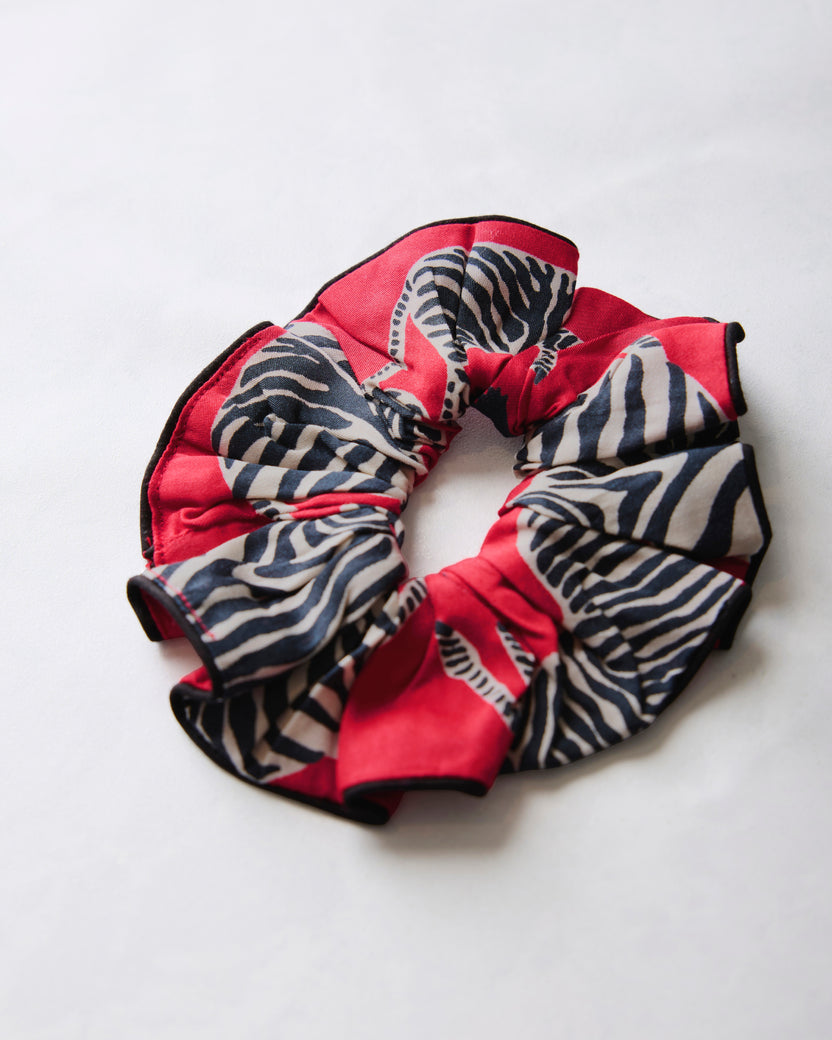 Red scrunchie with black-and-white zebra stripes arranged in a circle.
