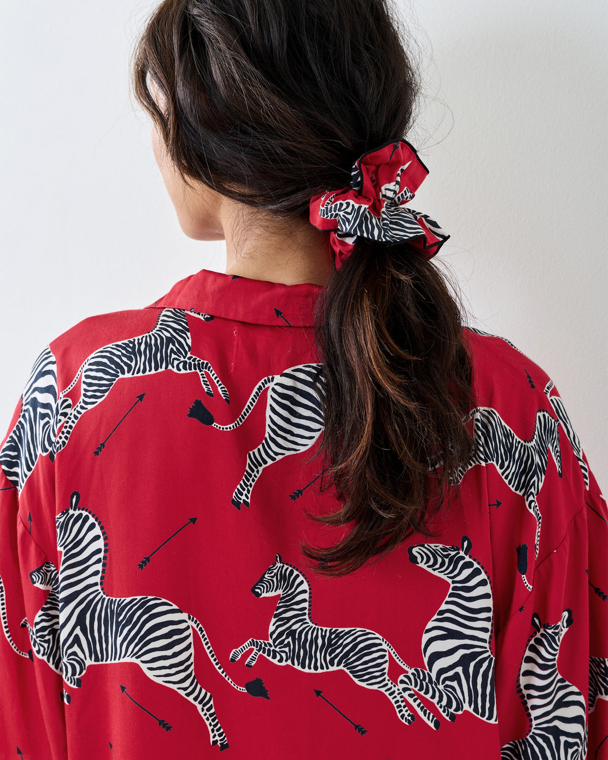 Back view of a person wearing the zebra-print scrunchie in a ponytail.
