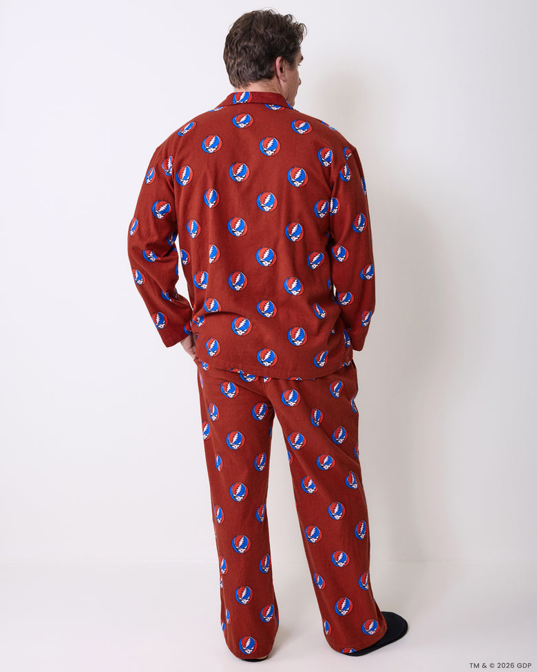 Back view of long-sleeved pajama top and matching pants in a red skull-and-lightning-bolt print.
