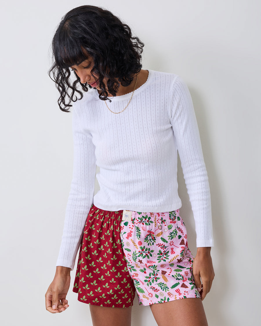 Person wearing two-tone boxer shorts with a red holly print on one side and a pink candy print on the other.