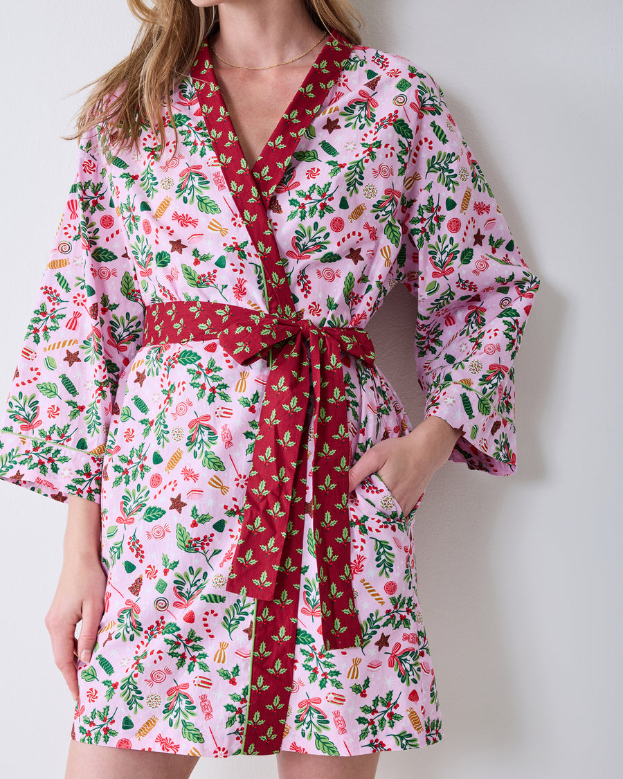 Front detail of the Sweet Tooth Getting Ready Robe in Candy Pink, showing the printed wrap design, red belt and trim, and a side pocket.