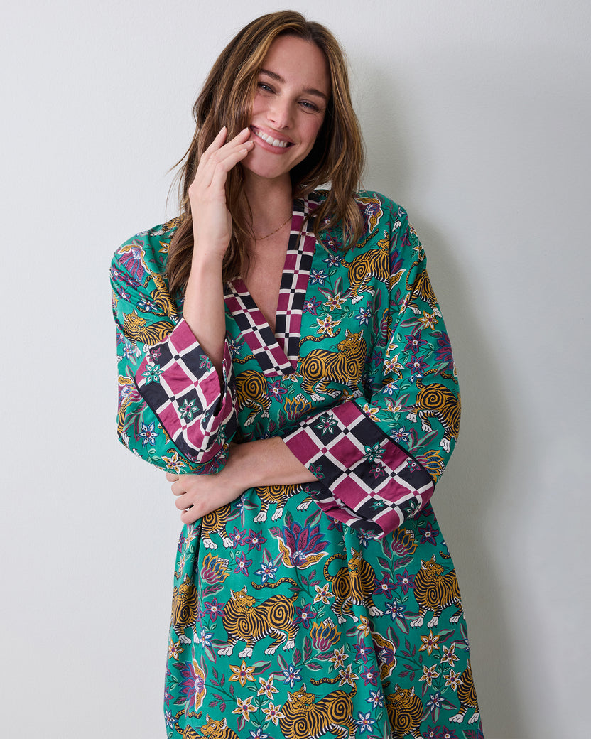 Front view of a model wearing the Royal Teal Tibetan Tigress caftan with tiger-and-floral print and contrasting trim.