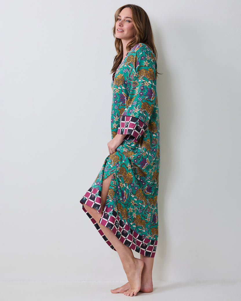 Side view of the Royal Teal Kennedy caftan with long sleeves, a front slit, and contrasting checkered trim at the cuffs and hem.