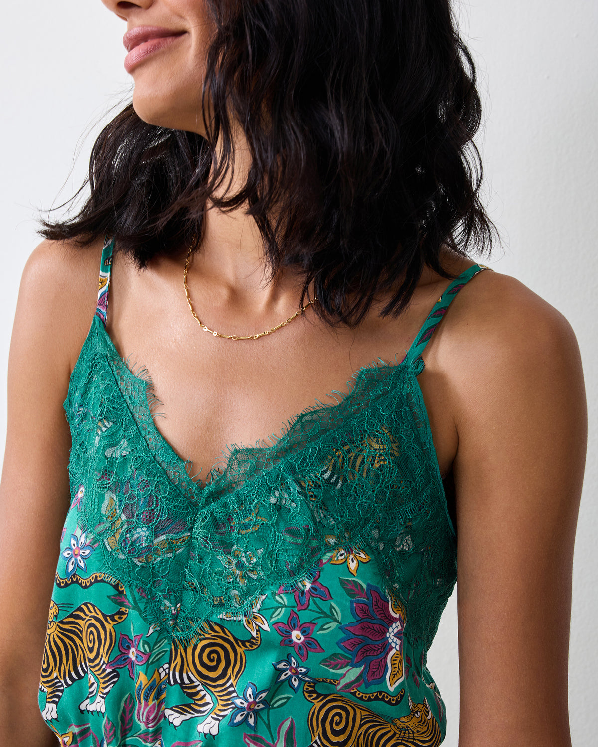 Close-up of the Royal Teal Tibetan Tigress Eco Satin Madeline Romper showing its lace-trimmed neckline and shoulder straps.