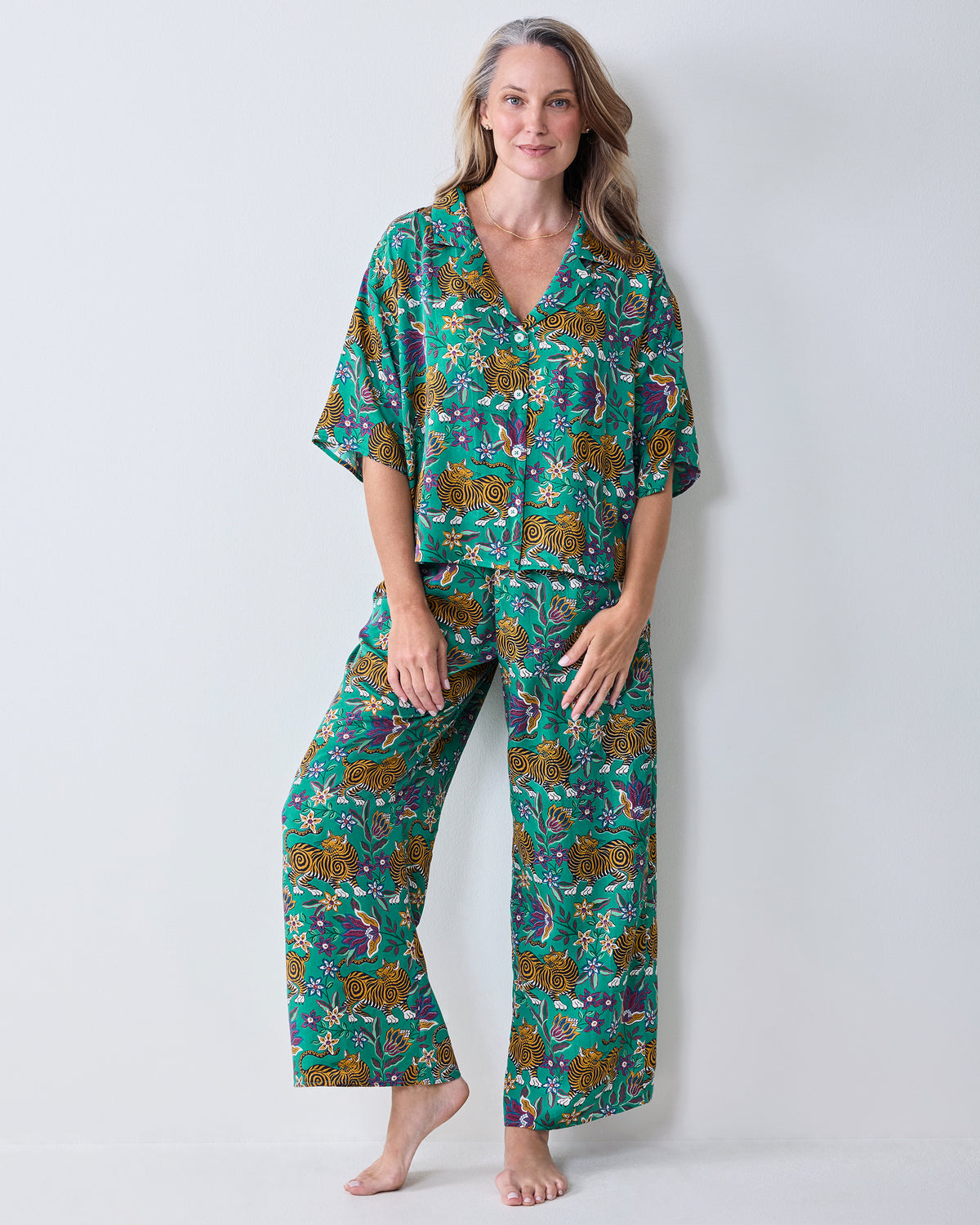Front view of the Royal Teal Wildest Dreams pajama set with a short-sleeved button-front shirt and wide-leg pants in a tiger-and-floral print.