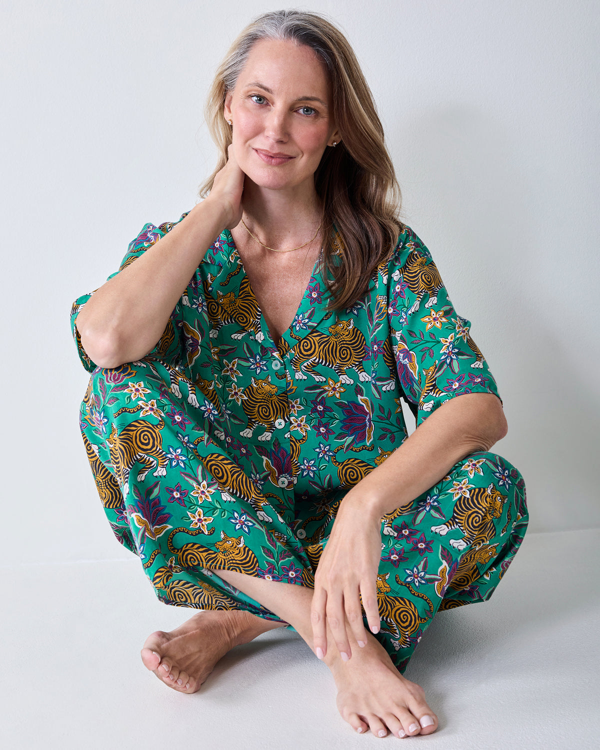 Seated view of the Royal Teal Wildest Dreams shirt and wide-leg pants set, showing the button-front shirt and tiger-and-floral print.
