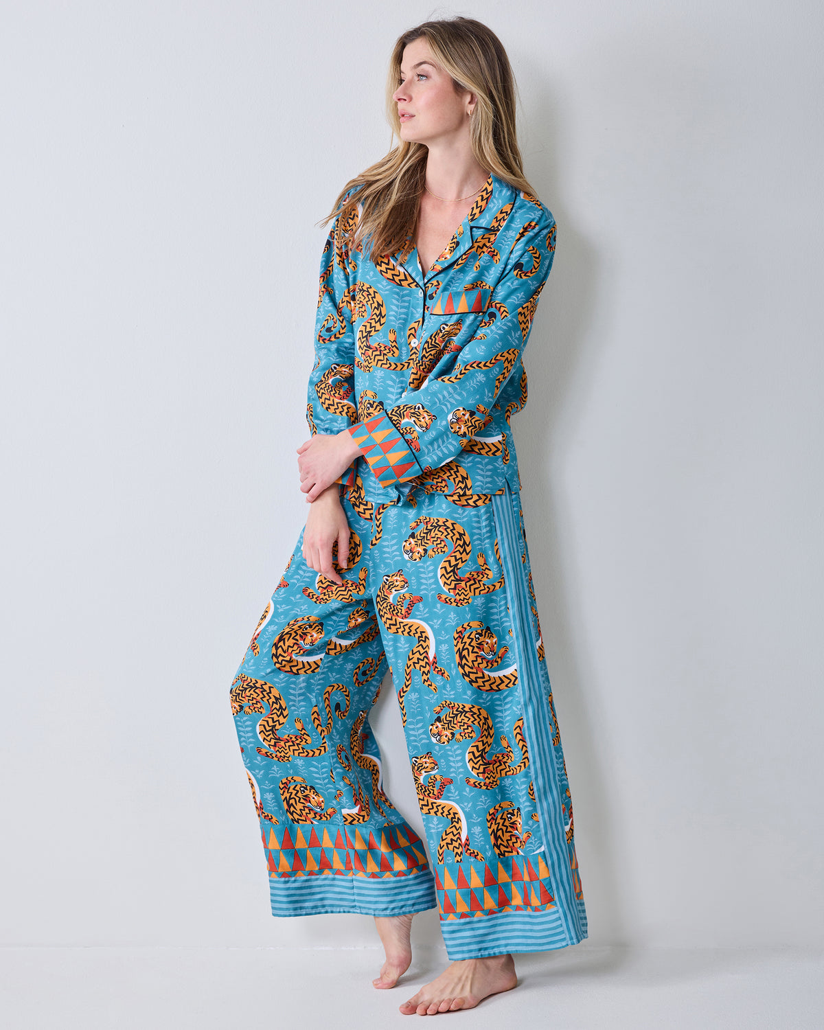Full view of a model wearing the Persian Turquoise Twisted Tiger pajama set with a collared top, wide-leg pants, and patterned hems.