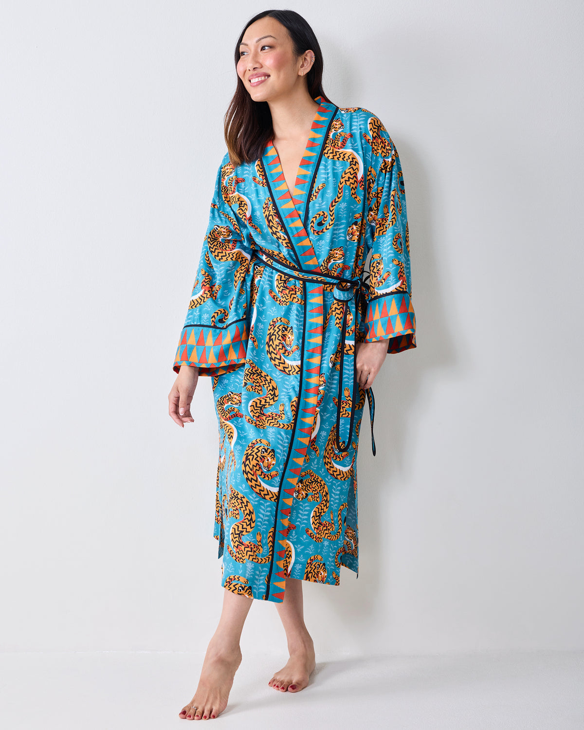 Three-quarter front view of a model wearing a turquoise tiger-print robe with a waist tie.