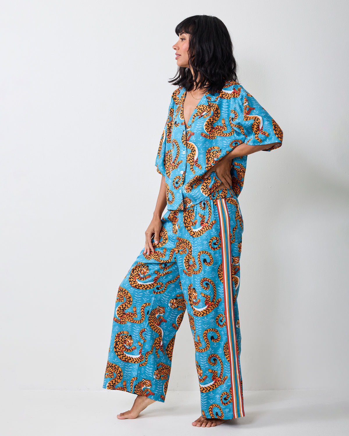 Full-length front view of a person wearing the turquoise Twisted Tiger pajama set with a cropped top and wide-leg pants.
