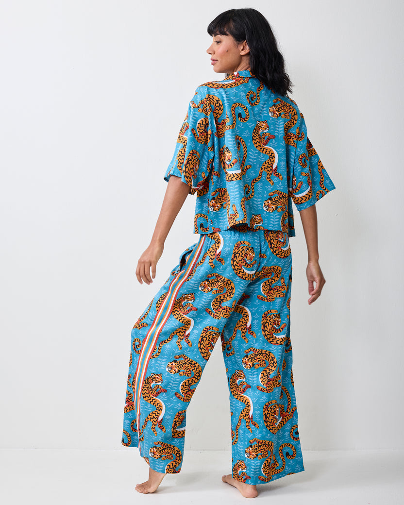 Back view of a person wearing the turquoise Twisted Tiger pajama set, showing the printed cropped top and wide-leg pants.