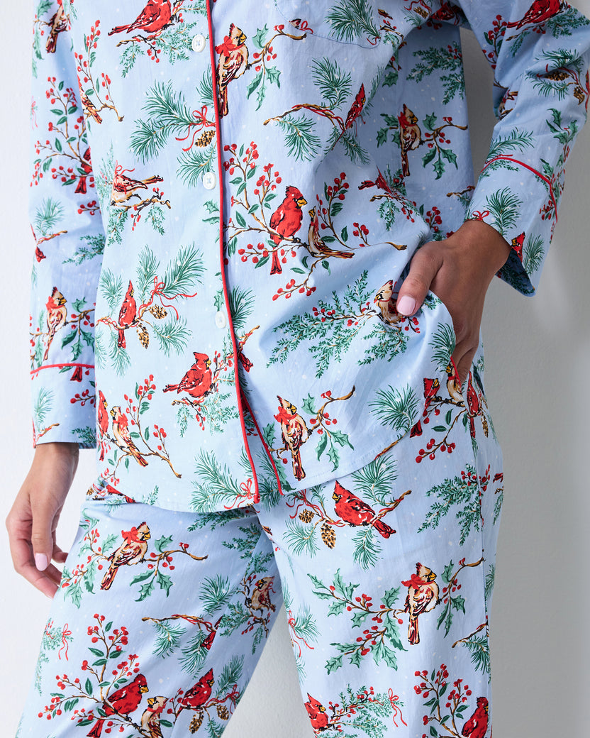 Close-up of the frosted blue Winter Cardinals long pajama set showing the button-front shirt, red piping, chest pocket, side pocket, and matching pants.