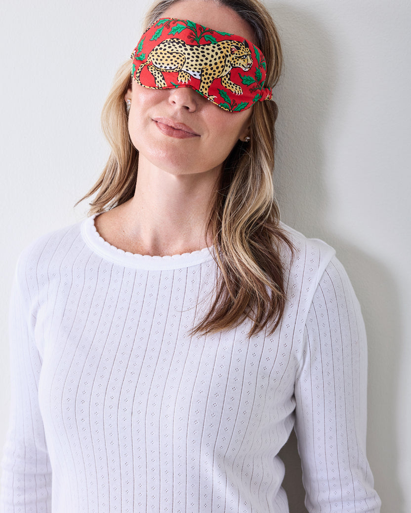 Person wearing the ruby leopard-and-holly printed eye mask over the eyes.