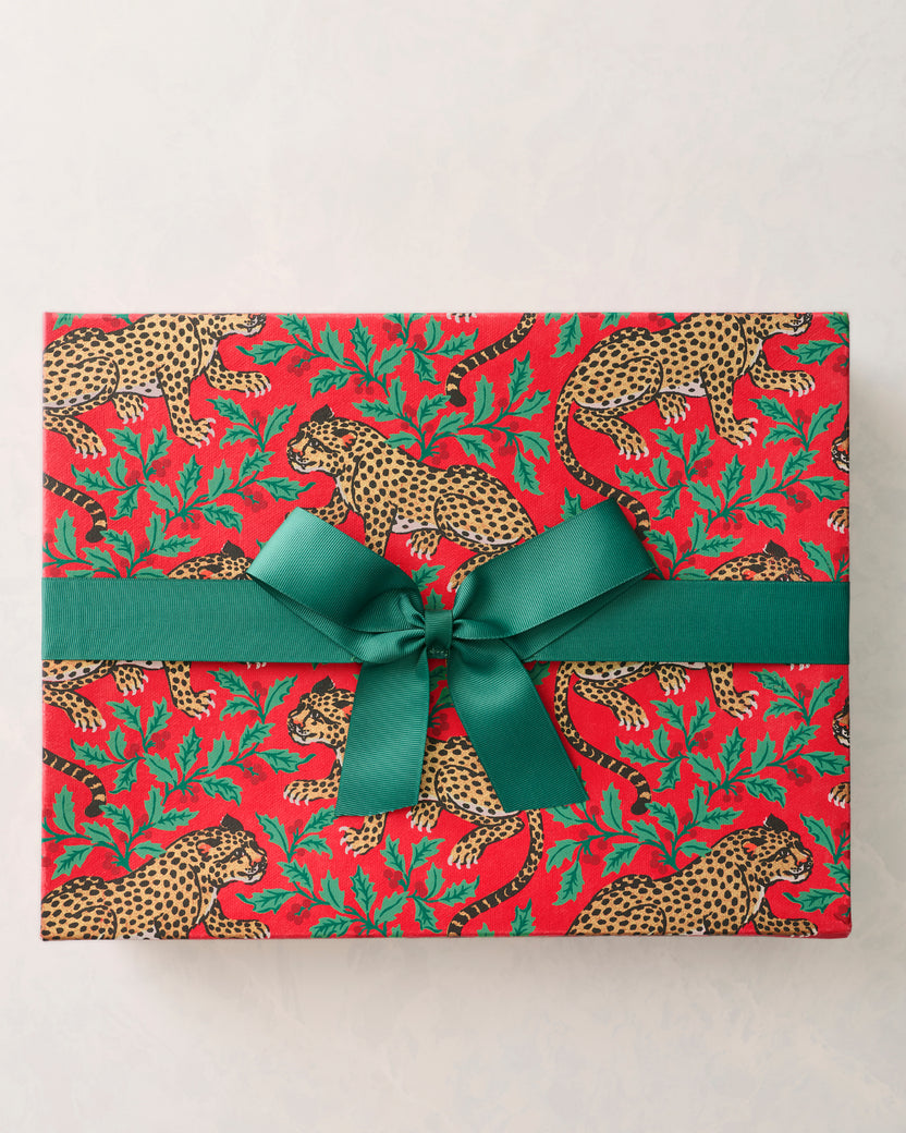 Red Winter Holly Bagheera handmade gift box wrapped with a wide green ribbon and bow, printed with spotted leopards and holly leaves.