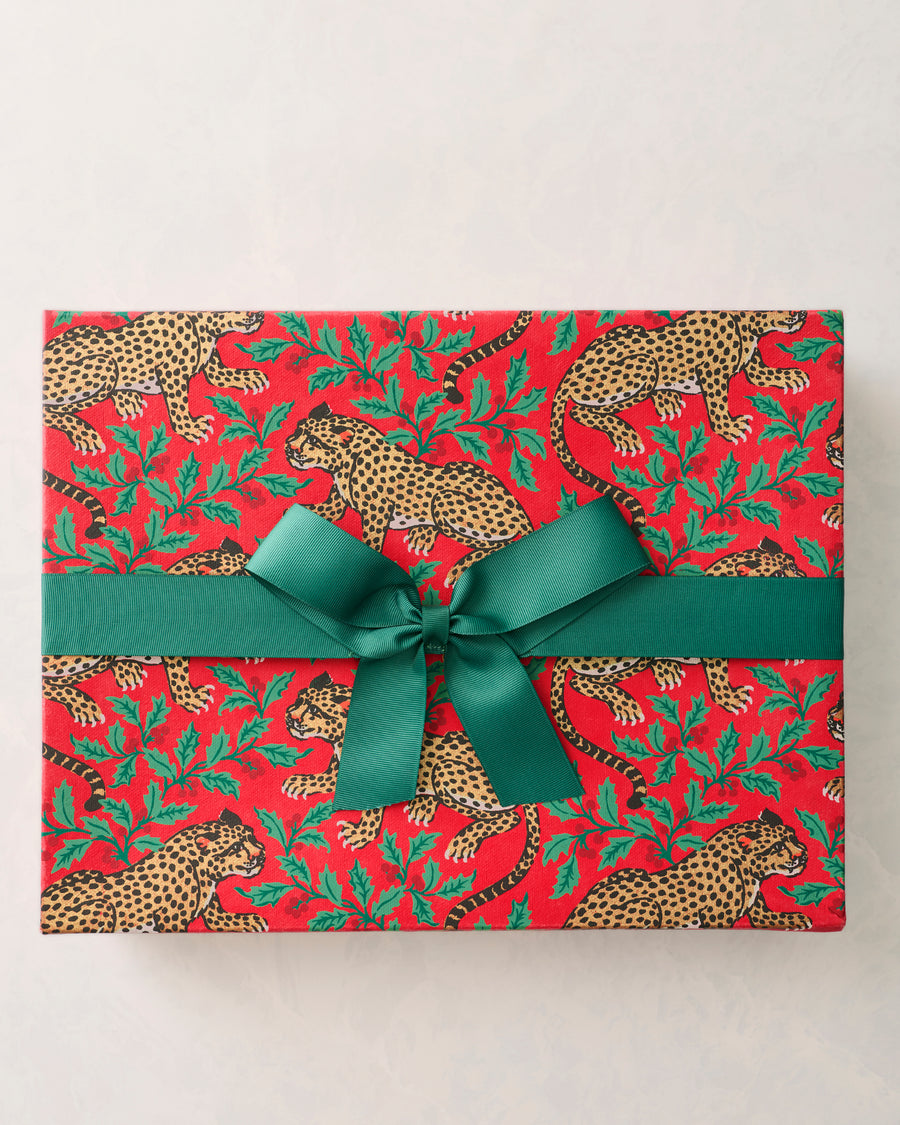 Red Winter Holly Bagheera handmade gift box wrapped with a wide green ribbon and bow, printed with spotted leopards and holly leaves.