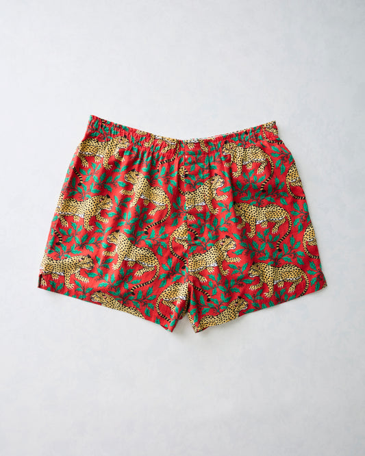Flat lay of red Winter Holly Bagheera men's boxer shorts with a leopard and holiday foliage print.