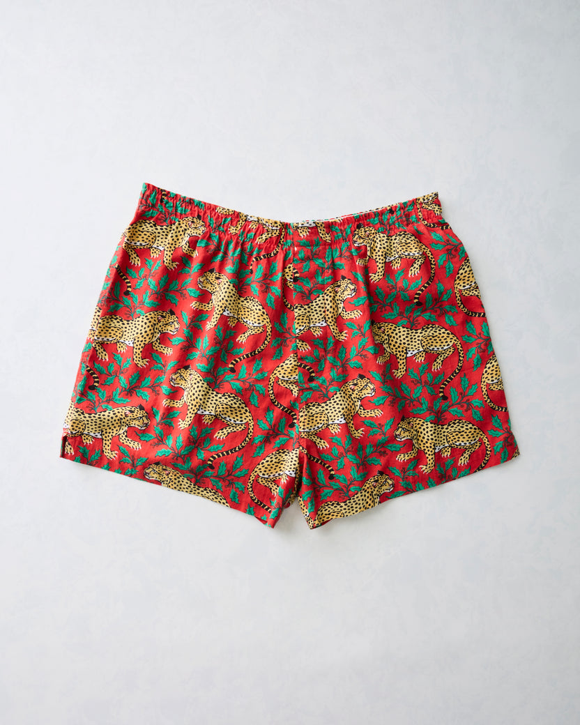 Flat lay of red Winter Holly Bagheera men's boxer shorts with a leopard and holiday foliage print.