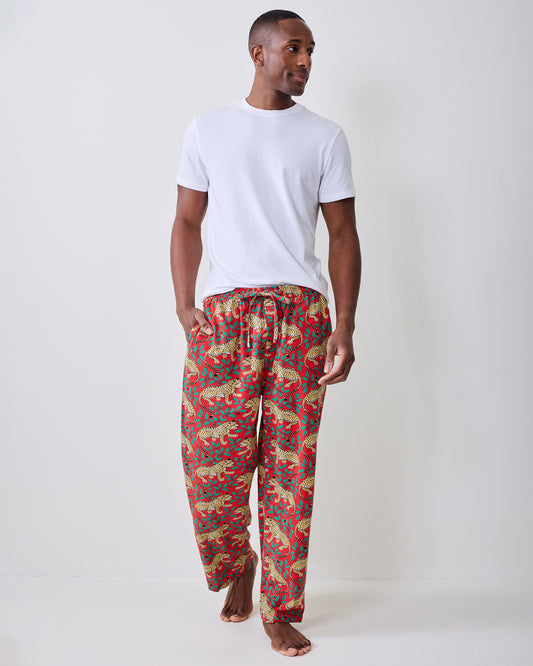 Front view of red pajama pants with a repeating leopard-and-leaf print, worn with a white T-shirt.