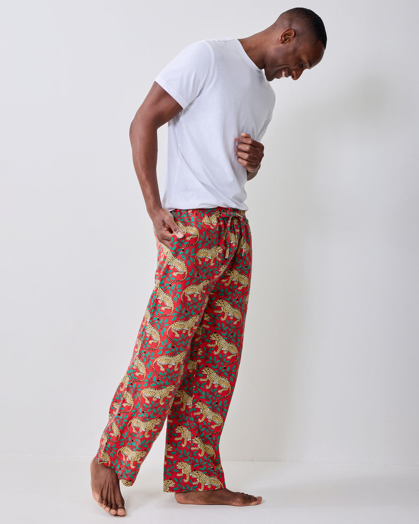 Side view of red pajama pants with a repeating leopard-and-leaf print.
