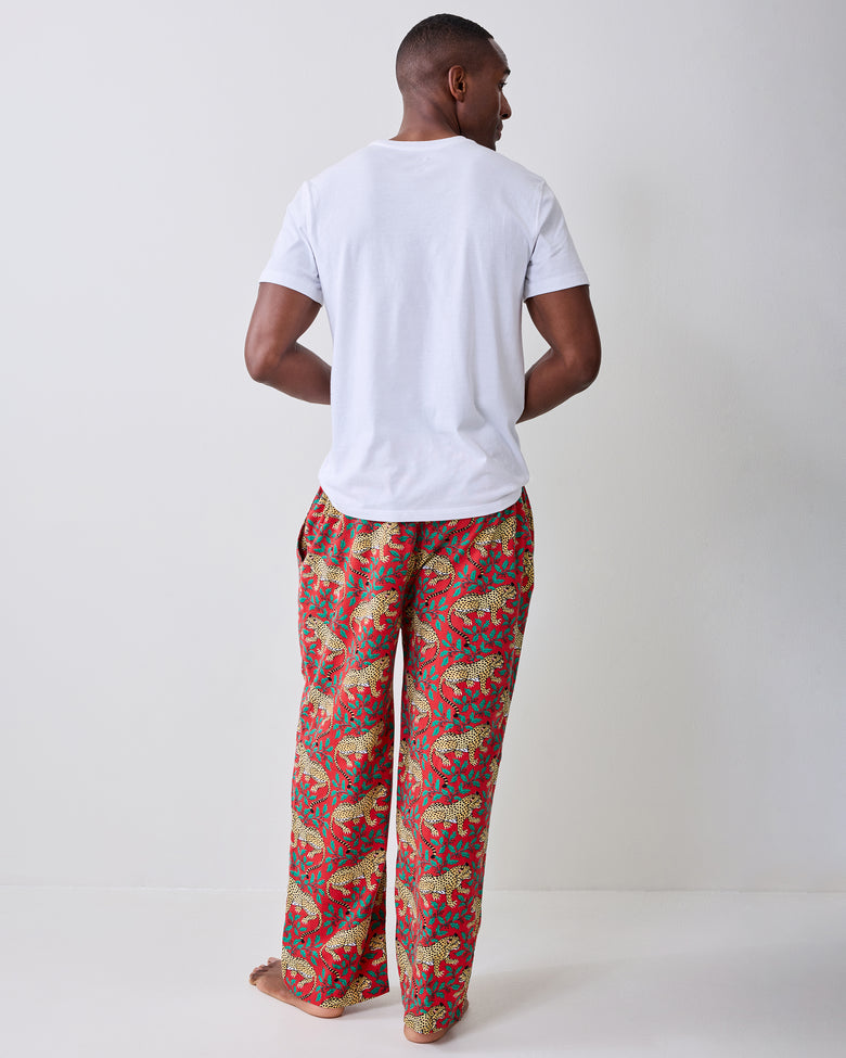 Back view of red pajama pants with a repeating leopard-and-leaf print.