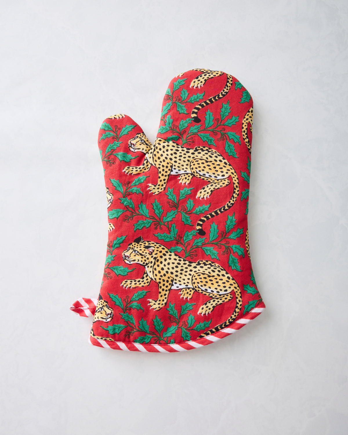 Ruby Winter Holly Bagheera oven mitt with leopard and holly leaf print, shown flat.