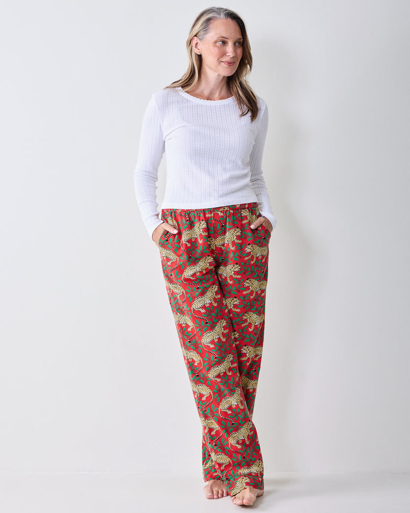 Winter Holly Bagheera pajama pants shown from the front with an all-over red leopard-and-holly print and side pockets.