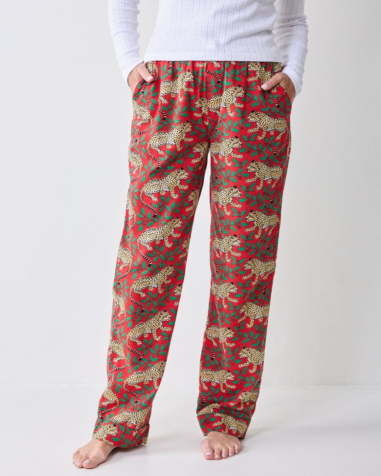Close front view of Winter Holly Bagheera pajama pants showing the waistband, drawstring, side pockets, and leopard-and-holly print.