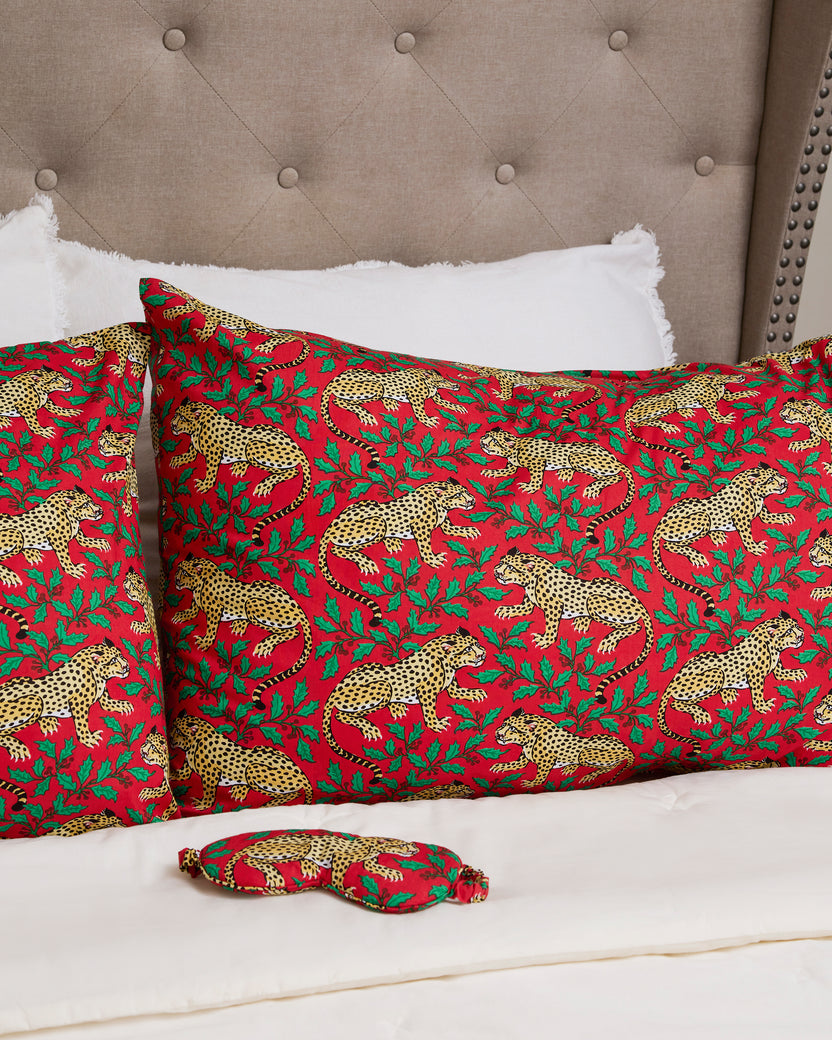 Winter Holly Bagheera patterned pillowcases arranged on a bed with a matching small fabric item in the foreground.