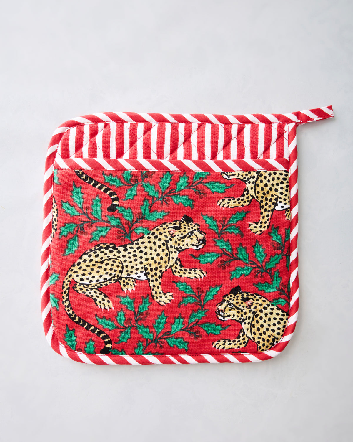 Ruby pot holder with a leopard-and-holly print and red-and-white striped trim.