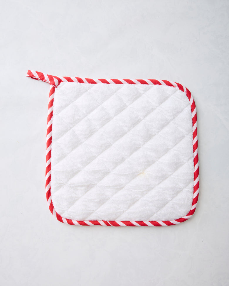 Back of a ruby pot holder showing white quilted padding and red-and-white striped trim.