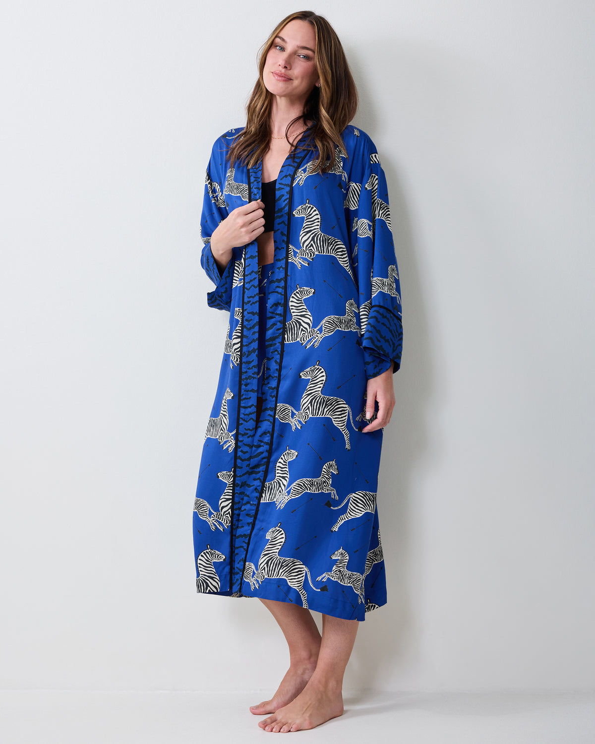 Front view of a denim-blue robe with a zebra print, worn open over a dark top.