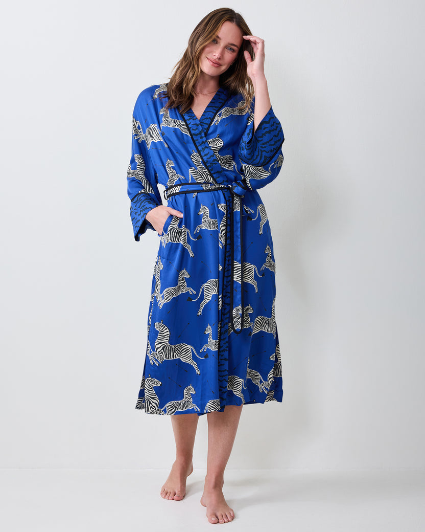 Full-length view of a person wearing a blue zebra-print robe with a tied belt and contrasting patterned trim.