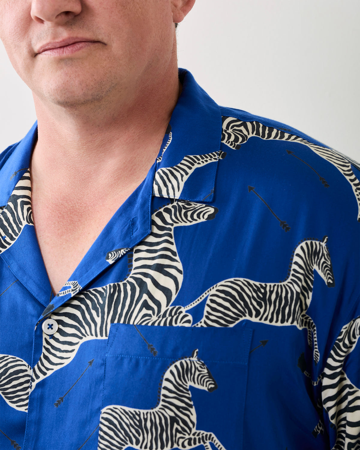 Close-up of a blue long-sleeve pajama shirt with zebra print and a chest pocket.